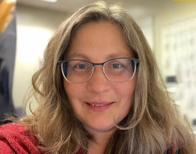 Woman in red shirt with glasses.