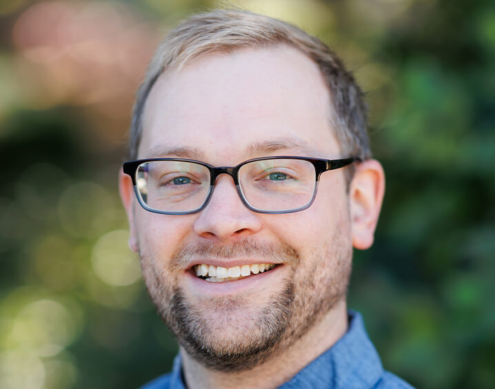 Man in blue shirt wearing glasses.