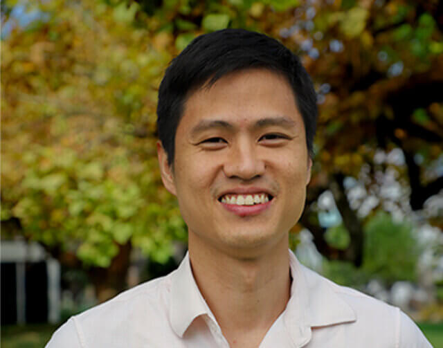 Man in short black hair in white button up.