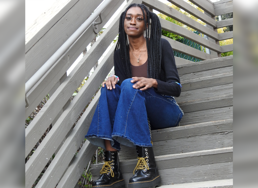 Kushnerniva Laurent ‘24 sits on an outdoor staircase and rests her hands on her knees.