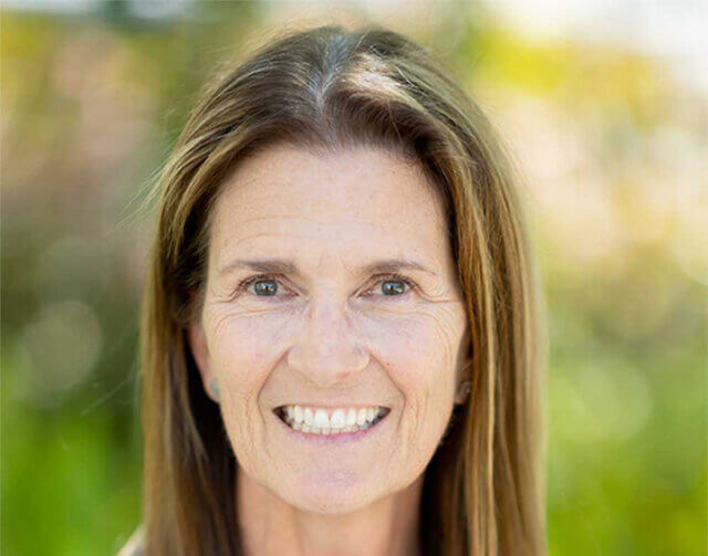Woman in light brown hair smiling.
