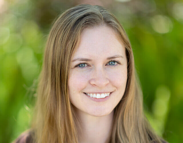 Woman in black shirt smiling.