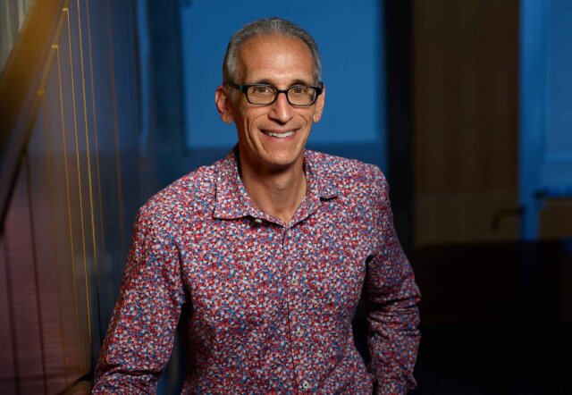 portrait of a man wearing a button up shirt and glasses