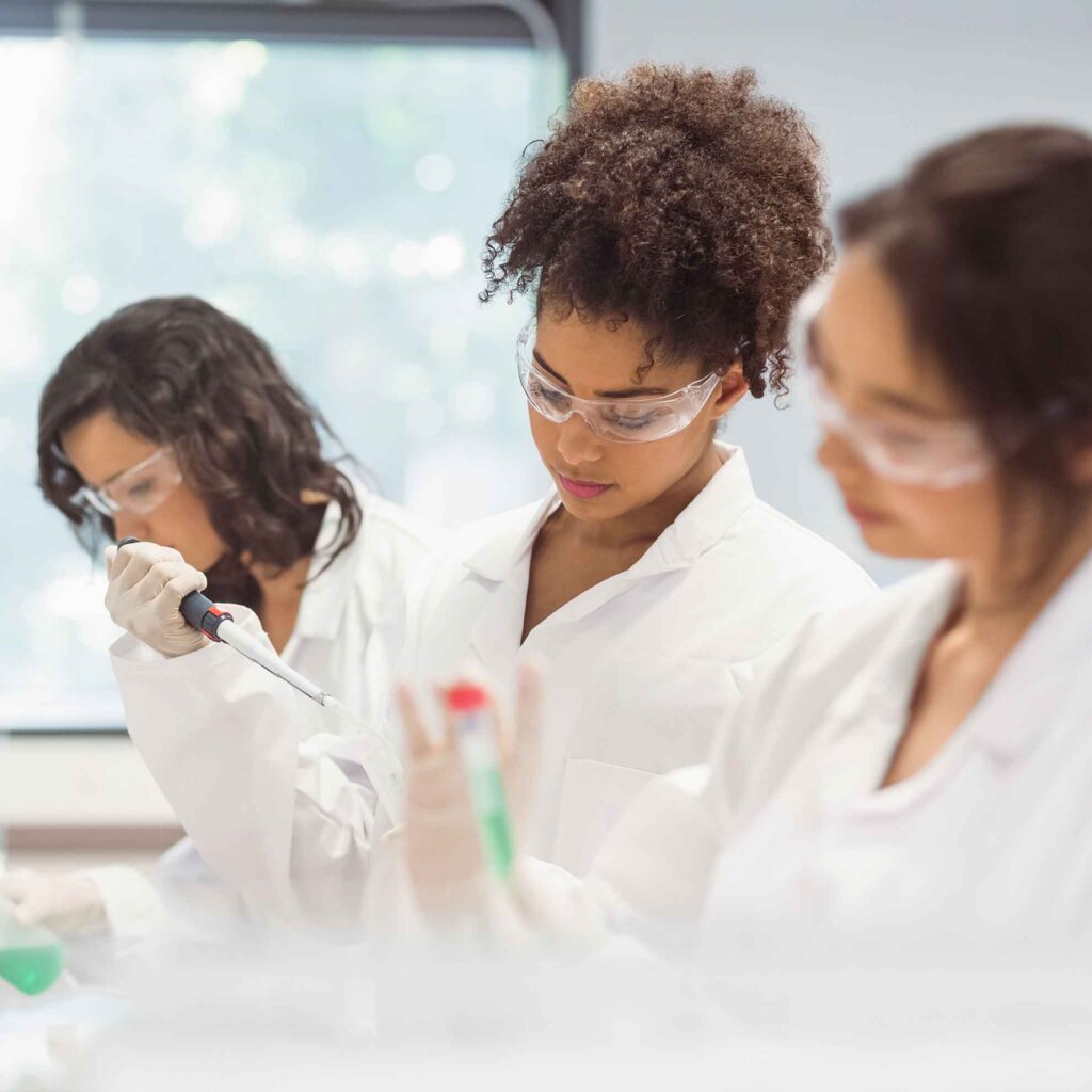 three female chemists work in a lab