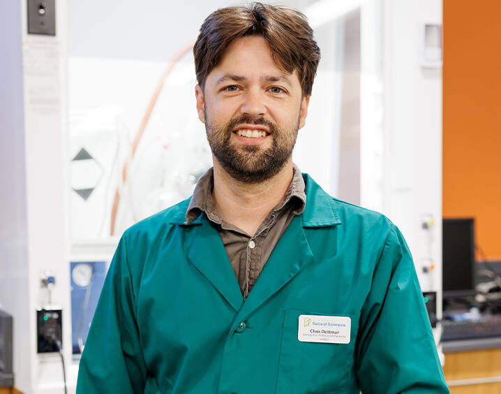 Man in brown shirt and turquoise lab coat.