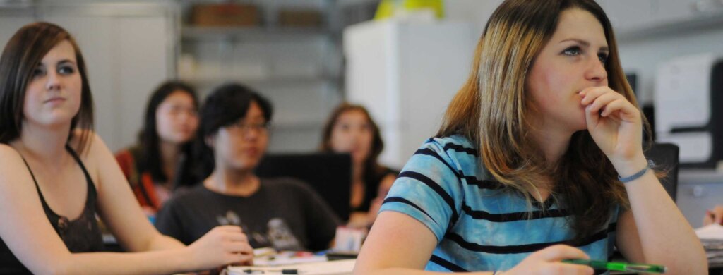 a group of students sit attentively in a classroom