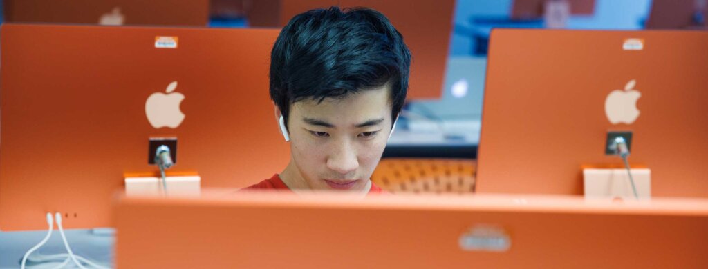 a student works in an mac computer lab