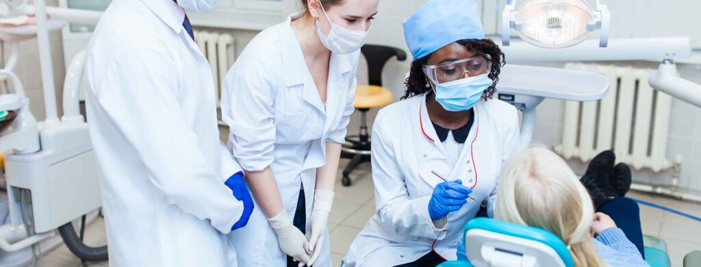 two students shadow a dentist in an office