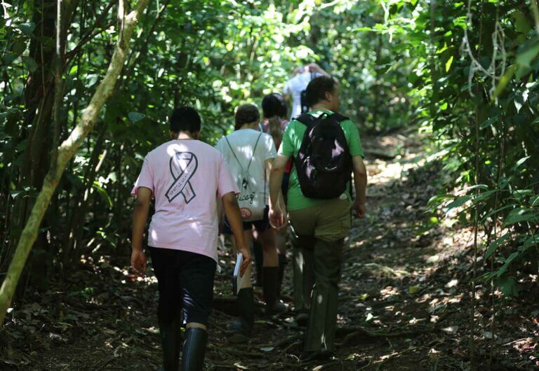 five people walk up a hill in the jungle in Costa Rica