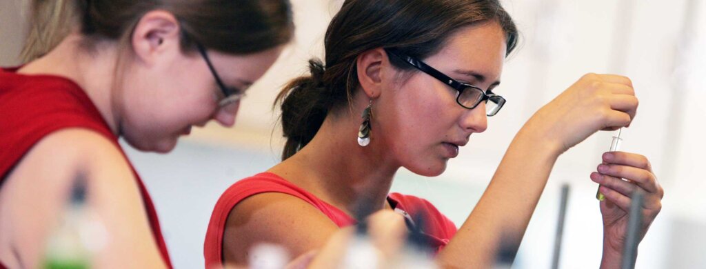 two students work with vials in a lab