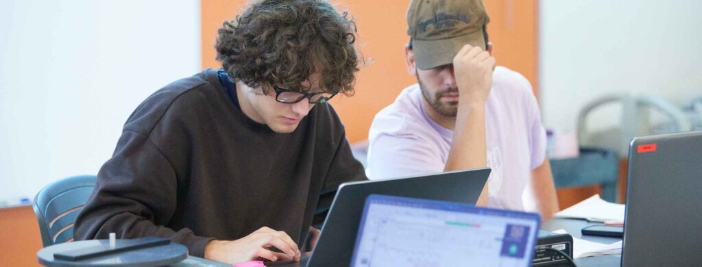 two students work together a laptop