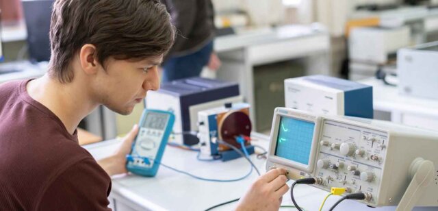 a physics student reads a frequency instrument