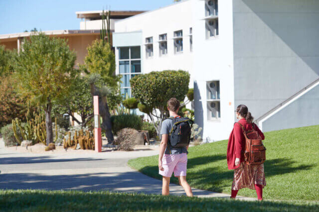 Students walk toward Pitzer College's academic quad