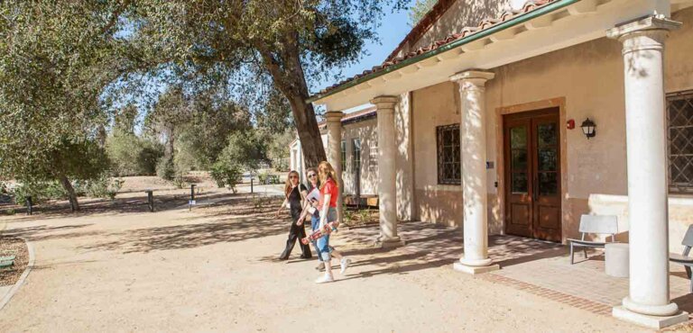 three people walk out fo the entrance of the robert redford conservancy