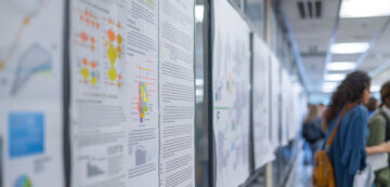 scientific posters line a wall in hallway.