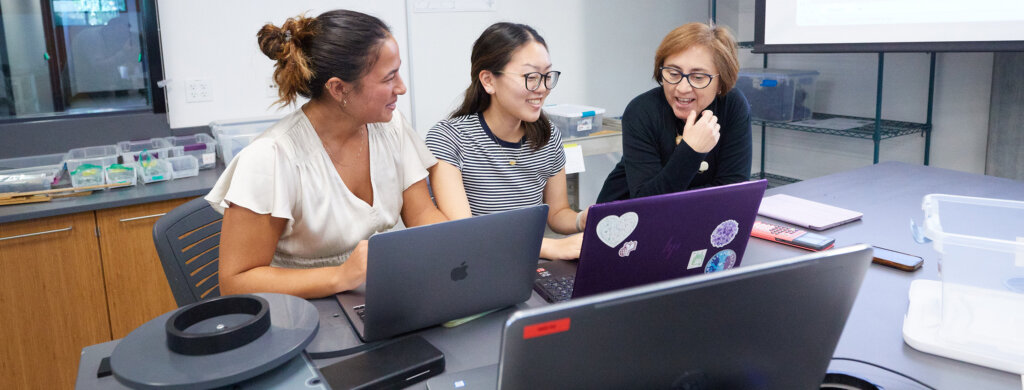 A professor guides her students through an experiment