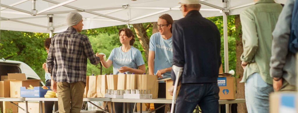 students give out food at an outside table