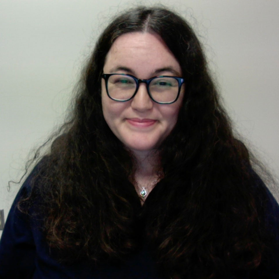 a woman with black glasses and long brown hair