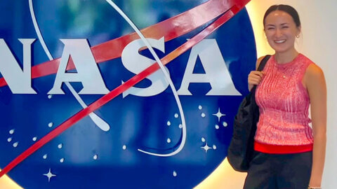 scotia rollins stands in front of a nasa logo